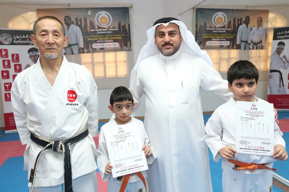 Young students holding grading certificates beside the sensei and a guest