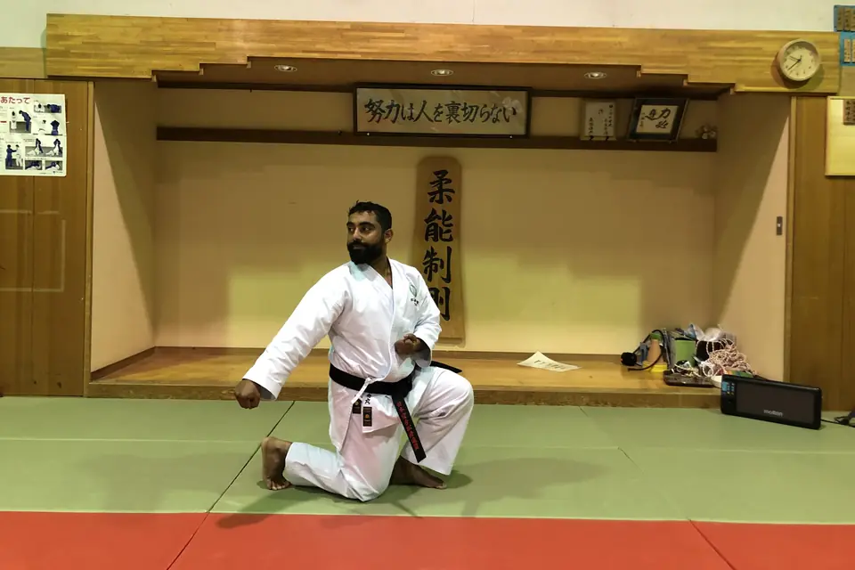 Sensei Najmal kneeling before the shomen of a traditional dojo in Japan