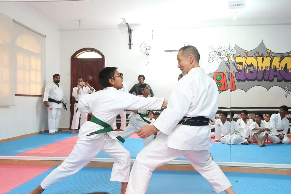 Sensei demonstrating a kumite technique with a green-belt student